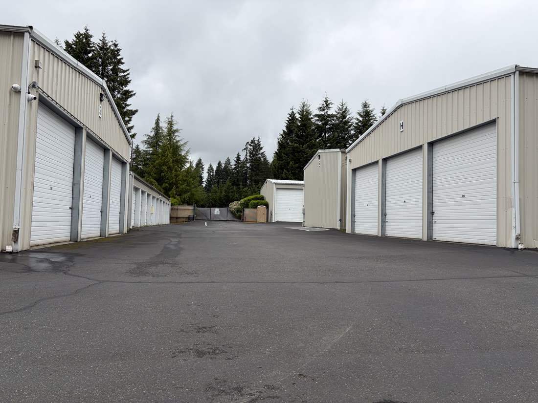 Rows of drive-up storage units along a wide paved aisle at ABC Storage